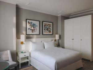 a bedroom with a white bed and a chair at Fairmont Le Montreux Palace in Montreux