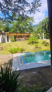 a swimming pool in front of a house at Camping Recanto da Mata in Paraty