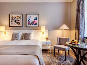 a hotel room with a bed and a table and a chair at Fairmont Le Montreux Palace in Montreux