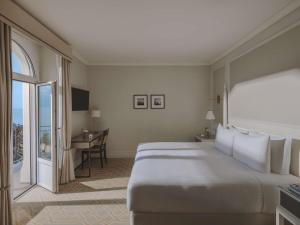 a hotel room with a large bed and a desk at Fairmont Le Montreux Palace in Montreux