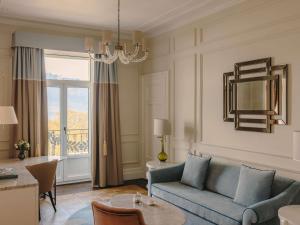 a living room with a blue couch and a table at Fairmont Le Montreux Palace in Montreux