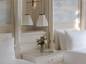 a bedroom with two lamps and a vase of flowers on a table at Fairmont Le Montreux Palace in Montreux