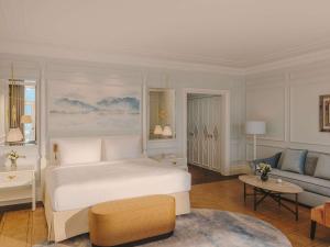 a bedroom with a white bed and a couch at Fairmont Le Montreux Palace in Montreux