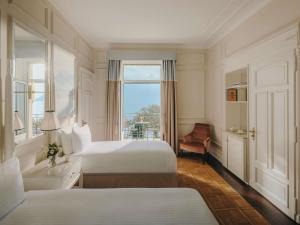 a hotel room with two beds and a window at Fairmont Le Montreux Palace in Montreux