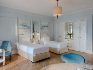 a bedroom with two beds and a table and chairs at Fairmont Le Montreux Palace in Montreux