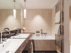 a bathroom with two sinks and a tub at Fairmont Le Montreux Palace in Montreux