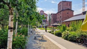 a row of benches in a garden next to a building at Luxury in the city 6 Ksiezy Mlyn&FUZJA in Łódź