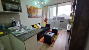 une cuisine et un salon avec un canapé dans une pièce dans l'établissement Oceana Suites Independencia, à Santiago