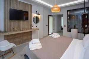 a room with a bed and a tv on a wall at Enjoy Lichnos Bay Village, Camping, Hotel and Apartments in Parga