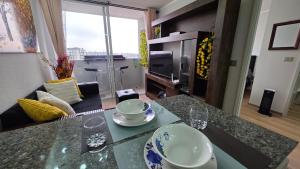 - un salon doté d'une table avec des bols et des assiettes dans l'établissement Oceana Suites Independencia, à Santiago 18 autres photos