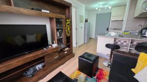 un salon avec une grande télévision à écran plat dans l'établissement Oceana Suites Independencia, à Santiago