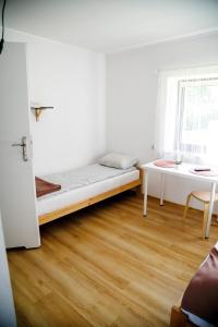a small room with a bed and a table at Jurajska47 in Wola Kalinowska