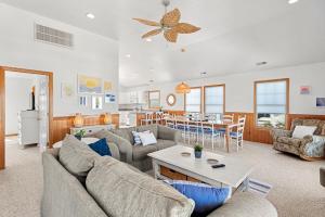 a living room with couches and a table and a kitchen at Weekend at Pinchys in Kill Devil Hills