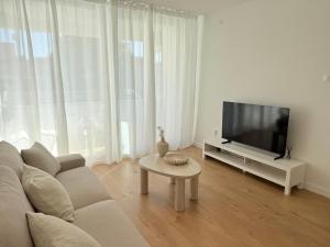 a living room with a couch and a tv and a table at Kalelarga Residence in Zadar