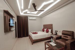a bedroom with a bed and a couch and a television at Lee Rooms in Nāgercoil