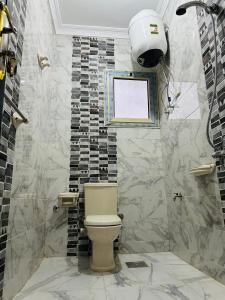 a bathroom with a toilet and a tile wall at golden mask pyramids view in Cairo