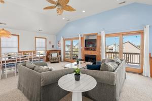 a living room with two couches and a table at Weekend at Pinchys in Kill Devil Hills