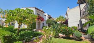 a garden with trees and plants in front of a building at Pueblo Andaluz New Luxury Townhouse Centre Nerja in Nerja