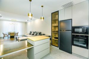 a kitchen and living room with a couch and a microwave at Megafun Apartment 3 Bedroom in Baku