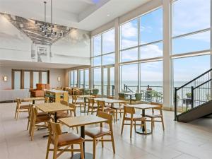 a restaurant with tables and chairs and large windows at Hampton Inn St Ignace Lakefront Mackinac in Evergreen Shores