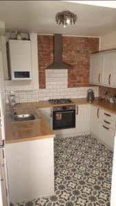 una cocina con fregadero y estufa horno superior en Eton House, en Derby