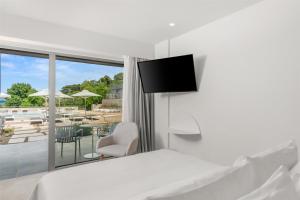 a hotel room with a bed and a view of a patio at Radisson Resort Plaza Skiathos in Kanapitsa