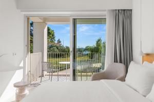 卡纳皮特萨Radisson Resort Plaza Skiathos的一间带床和阳台的卧室