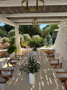een witte tafel en stoelen onder een pergola bij Borgo Fantese in Ostuni