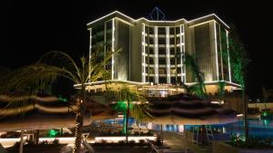 a hotel with a palm tree in front of a building at PALEMON Resort& Spa in Manavgat