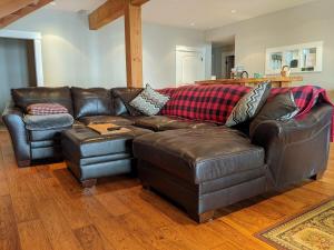 a brown leather couch in a living room at Mountain House of Wonder in Qualicum Beach +23 photos