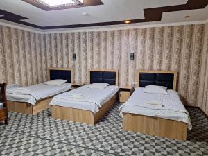 a room with three beds in a room at Shohruh Hotel in Guliston