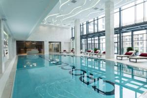 a large swimming pool in a building with windows at Megafun Apartment 3 Bedroom in Baku
