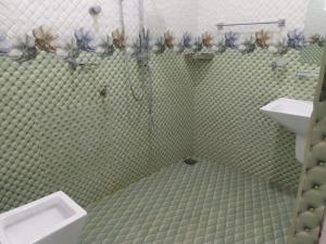 Baño de azulejos verdes con lavabo y aseo en Trinco NR Guest, en Trincomalee