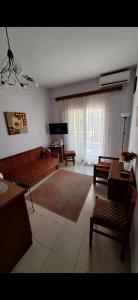 Una sala de estar con un sofá y un televisor. en The house by the sea, en Skála Foúrkas