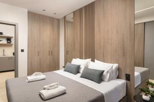 ハニア・タウンにあるES Apartments ARIONのタオルが敷かれた大きなベッドのある寝室