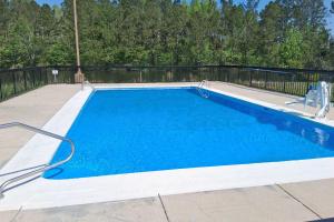 a swimming pool with blue water in a yard at Baymont by Wyndham Metter in Metter