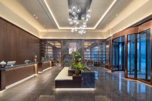 a lobby with a library with a chandelier at Days Hotel by Wyndham Weihai Huoju Eight Street in Weihai