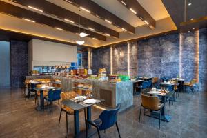a restaurant with tables and chairs and a bar at Days Hotel by Wyndham Weihai Huoju Eight Street in Weihai