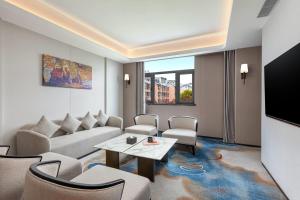 ein Wohnzimmer mit Couch und Fernseher in der Unterkunft Wyndham Garden Changsha University Town in Changsha