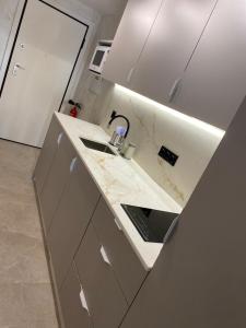 cocina con encimera de mármol y fregadero en SUITE PLAYA CARIHUELA Apartamentos, en Torremolinos