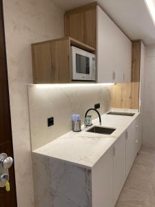 a kitchen with a sink and a microwave at SUITE PLAYA CARIHUELA Apartamentos in Torremolinos +16 photos