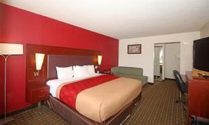 a hotel room with a bed and a red wall at Knights Inn Pilot Mountain in Pilot Mountain +25 photos