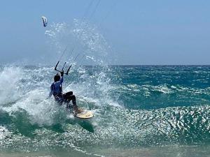 a man riding a wave on a surfboard in the ocean at F3Sun CASA JACOB - 2 BR, Green Oasis, Costa Calma, Fuerteventura in Costa Calma