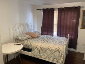 ein kleines Schlafzimmer mit einem Bett und einem Tisch in der Unterkunft Peculiar N 5th street in Newark