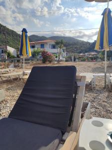 stół, krzesła i parasole na plaży w obiekcie Anastasia Studios & Apartments w mieście Panormos