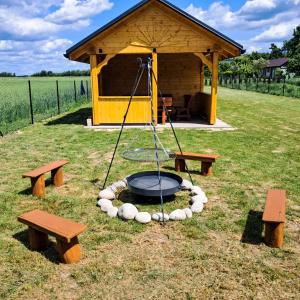 a picnic shelter with a fire pit and benches at Agroturystyka - TI AMO Nielisz in Nielisz