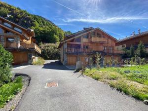 ein Haus auf einer Straße neben einem Berg in der Unterkunft Appartement neuf et cosy, proche des pistes, avec cheminée et parkings dédiés - FR-1-570-11 in Levassaix