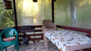 a bed and two chairs on a porch at Casa Damian in Bertea