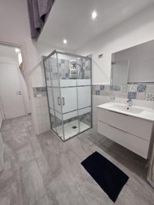 a bathroom with a glass shower and a sink at Giomasue' in Porticello