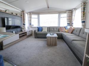 a living room with a couch and a tv at V9 Ty Mawr Holiday Park in Abergele